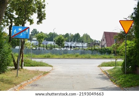The road with the exit from a housing estate with single-family houses with priority yield and end residence zone signs