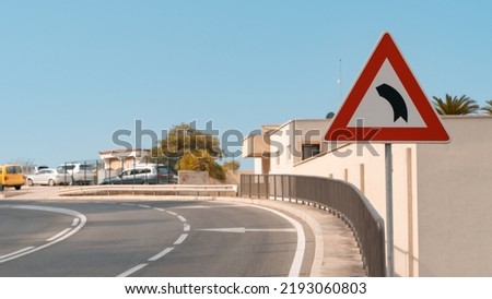 triangular road sign of a dangerous turn. Traffic control tool. A sign informing about the approach to a section of the road with a dangerous turn. Royalty-Free Stock Photo #2193060803