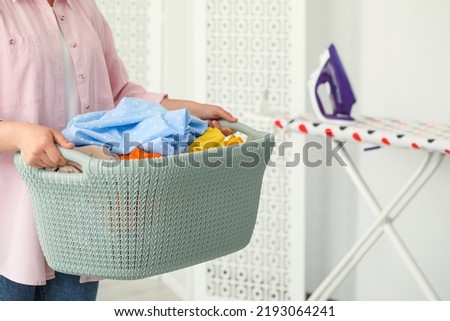 Woman with basket full of clean laundry indoors, closeup Royalty-Free Stock Photo #2193064241