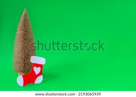 Christmas tree and Santa's sock on a green background. Happy Holidays