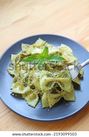 Fork Scooping Mouthwatering Farfalle or Bow-tie Pasta in Pesto Sauce Royalty-Free Stock Photo #2193099503