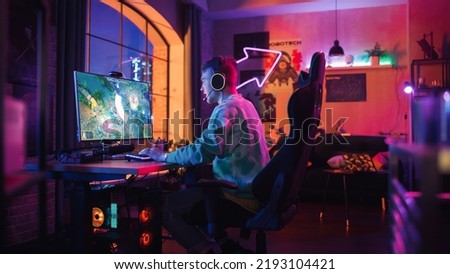 Successful Gamer Playing and Winning in PvP RPG Strategy Video Game in Which Players Fight in a Battle Royale Tournament on Personal Computer. Stylish Man Celebrating Victory in Cozy Room at Home.