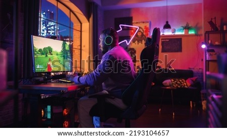 Hyped Gamer Playing PvP Shooter Video Game in Which Players Fight in a Battle Royale Tournament on His Personal Computer. Room and PC with Neon Lights. Stylish Black Man in Cozy Room at Home.