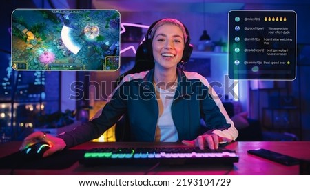 Excited Female Streamer Playing a Video Game Online. Stylish Woman Streaming Gameplay from Her Home, Living Room in Modern Flat. Followers Engaging Through Interface During Live Broadcast on Internet. Royalty-Free Stock Photo #2193104729