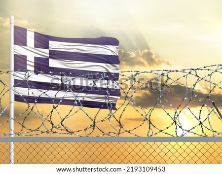 Flagpole with the flag of Greece against the sky and behind a fence with barbed wire. The concept of protecting the borders of territories.