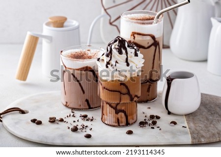 Mocha latte and iced frappe topped with whipped cream and chocolate syrup, refreshing and sweet coffee drinks Royalty-Free Stock Photo #2193114345