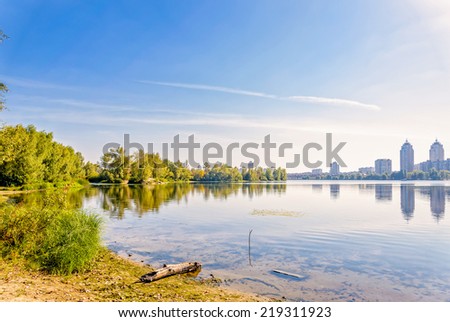 A quiet view of the river under the late summer sun, with the city skyline in the distance