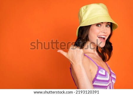 Profile photo of impressed brunette lady index promo wear cap violet top isolated on orange color background