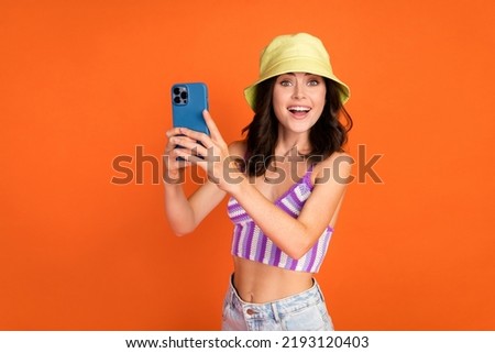 Photo of brunette impressed lady shoot picture wear hat top isolated on orange color background