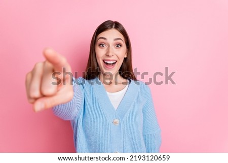 Photo of speechless pretty nice young girl in blue pullover staring open mouth pointing finger on camera isolated on pink background