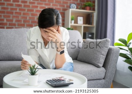 Asian women are stressed and confused about calculating expenses from invoices or invoices,  have no money to pay, mortgage or loan. Debt, bankruptcy or bankrupt concept.