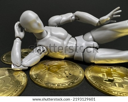 A Figurine is lying on top of a bitcoin. Cryptocurrency, speculation, successful concept.