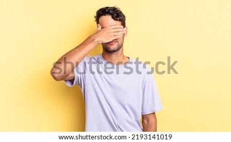 hispanic handsome man covering eyes with one hand feeling scared or anxious Royalty-Free Stock Photo #2193141019