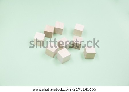 Randomly stacked small Wooden cubes lie on a green background. Blank for the banner.