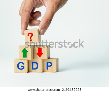 financial symbols, wooden blocks of GDP with red and green arrow showing prediction and question mark