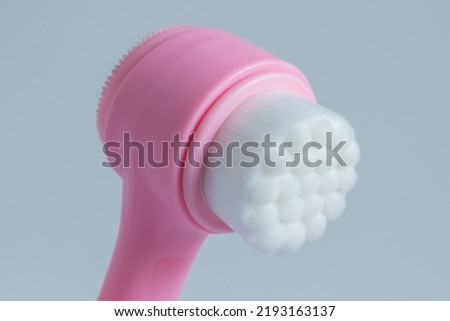 Pink face cleansing brush, closeup. Cosmetic accessory.