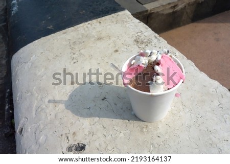 Ice cream with three flavors in paper cup.