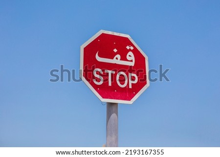 stop sign in arabic. Stop sign with the text in Arabic in the city of Dubai, United Arab Emirates. View from Bajaoj of the Arabic stop sign with blue sky behind