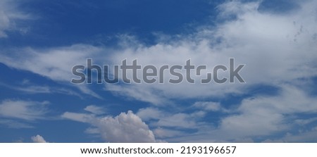 Beautiful white clouds on deep blue sky background. Elegant blue sky picture in daylight. Large bright soft fluffy clouds are cover the entire blue sky. Cumulus clouds against blue sky. No focus