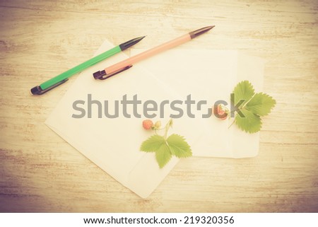 vintage photo of Blank picture frame paper with plants on wooden table