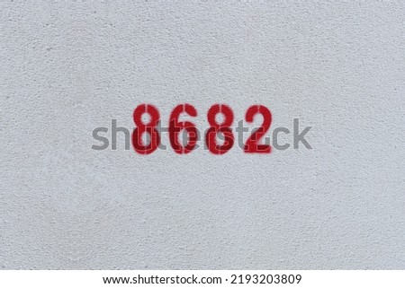 Red Number 8682 on the white wall. Spray paint.
