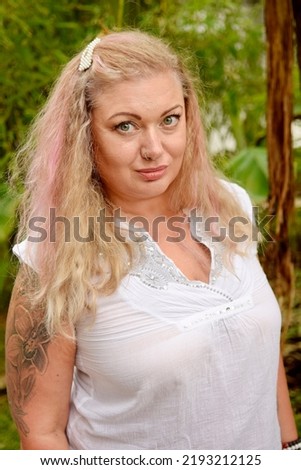 Woman in white with pearls clip pink hair portraits in tropical garden outdoors