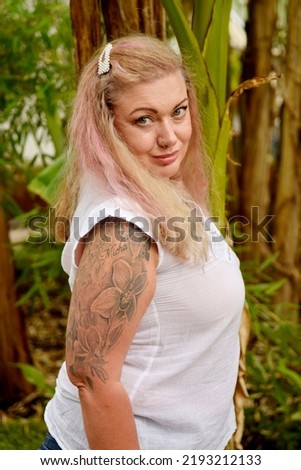 Beautiful smiling pretty busty curvy model with tattos alternative girl pink hair  top summer clothes fashion white background pretty face emotion expression nature green background