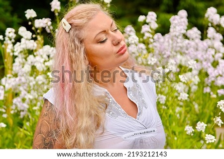 Woman in white with pearls clip pink hair portraits in flower garden outdoors nose piercing summer green nature alternative model different diversity real people unique style magazine blog psychology
