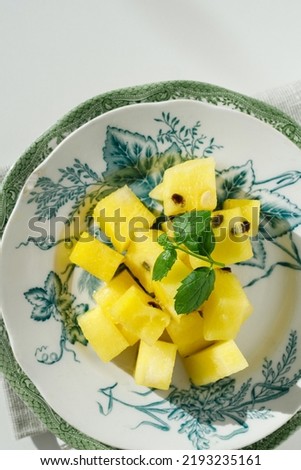 Pieces of ripe yellow watermelon and mint on vintage plates and white background. Top view. Copy space