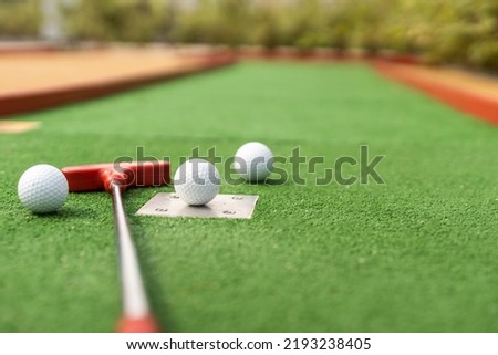 Close-up of miniature golf hole with bat and ball Royalty-Free Stock Photo #2193238405