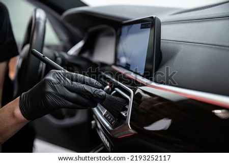 car detailing studio employee carefully cleans the air vents Royalty-Free Stock Photo #2193252117
