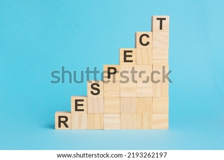 The word respect is written on a wooden cubes. Blocks on a bright blue background. Corporate hierarchy concept and multilevel marketing. Selective focus.