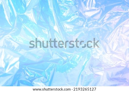 Iridescent foil texture background. Holographic wrinkled surface. Vibrant blue gradient template for design. Banner with copy space