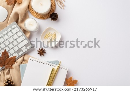 Autumn business concept. Top view photo of workplace keyboard notebook pen candles rattan serving mat clips fallen maple leaves anise pine cones and plaid on isolated white background