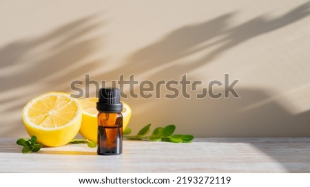Essential oil in brown bottle and cut lemon on a background Royalty-Free Stock Photo #2193272119