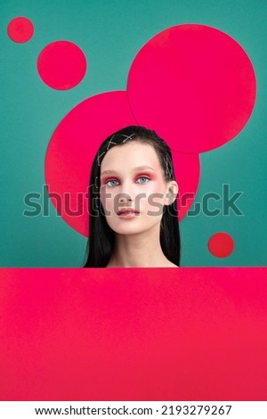 Portrait of female fashion model with geometry circle on studio background. Beautiful woman with trendy make-up and well-kept skin. Vivid style, beauty concept