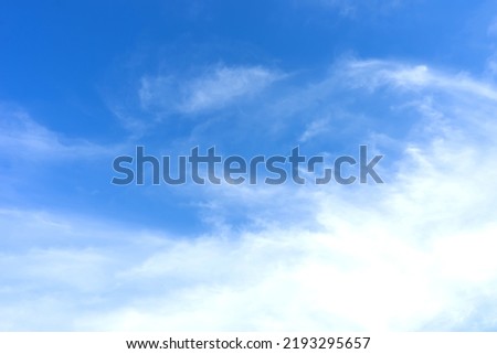 Blue sky with white clouds in sunny day. Beauty clear cloudy sky in sunshine calm air bacground. Natural background texture, backdrop, wallpaper, element for design