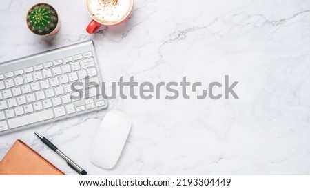 Top view, White marble Office desk with keyboard computer, cup of coffee, pen, mouse and notebook, copy space, Mock up..	