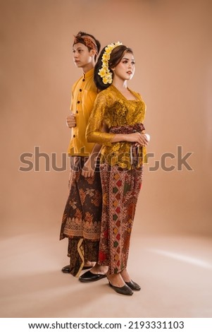 portrait of balinese couple with traditional costume over isolated background studio