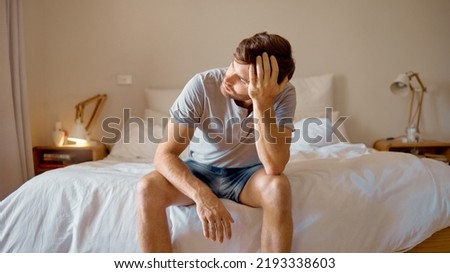 Depression, mental health and sad man in stress feeling bad, upset and depressed alone in his home, house or hotel suite. Wake up, morning and frustrated, unhappy male in bedroom tired with anxiety Royalty-Free Stock Photo #2193338603