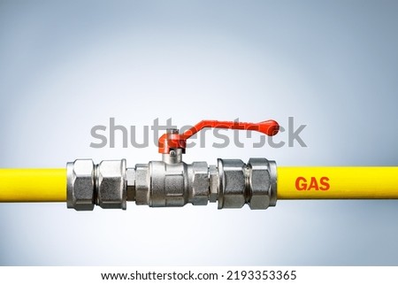 Yellow gas pipe with valve on grey background with copy space. Gas transportation system. Repair concept. Royalty-Free Stock Photo #2193353365