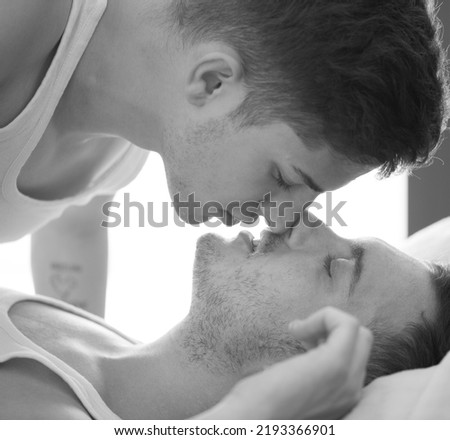 Gay couple relaxing together, LGBT. Two young men kissing and hugging. Black and white portrait. Young men romantic family in love. Happiness concept Royalty-Free Stock Photo #2193366901
