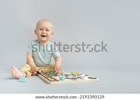Children's educational toys. Wooden game board. Busy board for children. Eco friendly lifestyle. Toddler works with Montessori material for fine motor skills, sensory play. Royalty-Free Stock Photo #2193390129