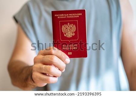 Russian tourist passport in the hand of a citizen. Immigration, legalization, travel concept. Royalty-Free Stock Photo #2193396395