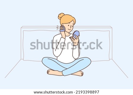 Woman sitting on bed at home doing makeup. Happy female enjoy beauty routine in bedroom. Cosmetics and skincare concept. Vector illustration.  Royalty-Free Stock Photo #2193398897