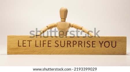 Let life surprise you written on wooden surface. Motivation and personal development