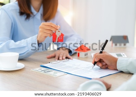 Home sales and home insurance concept. Real estate agent talked about the terms of the home purchase agreement and asked the customer to sign the documents to make the contract legally.