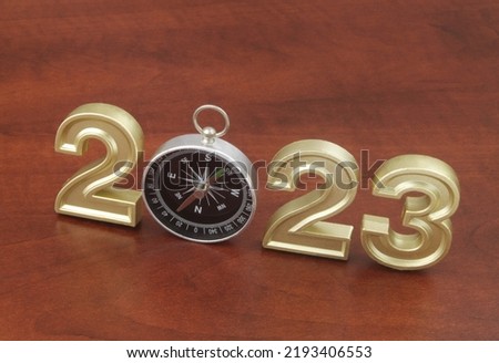 Business directions in 2023 concept, numbers 2023 and compass on wooden background.