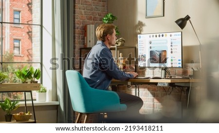 Young Handsome Man Using Desktop Personal Computer to Check Social Media Wall Feed, Live Stream Videos, Posts, Pictures. Mock-up Posts: Creativity, Tech, News, Science, Lifestyle Content.