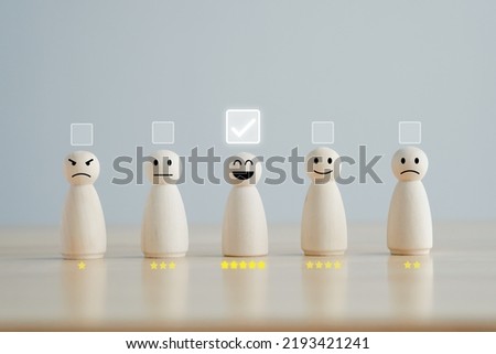 Select happy face wooden figure with 5 star. Customer service rating experience and feedback emotion and satisfaction survey. Human Resources management choosing positive attitude to team. Royalty-Free Stock Photo #2193421241